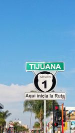 Low angle view of road sign against blue sky