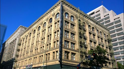 Low angle view of buildings against clear blue sky