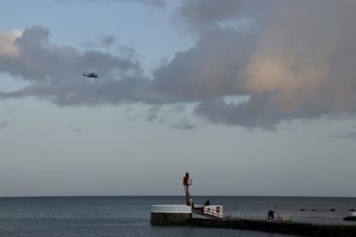 Helicoptor above harbour wall