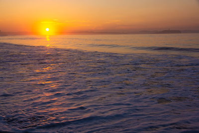 Scenic view of sea against orange sky