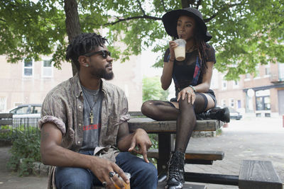 A young man and a young woman at a picnic table.