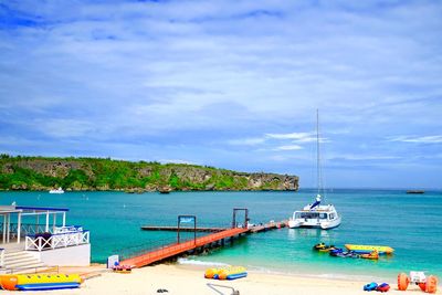 Sailboats moored on sea against sky