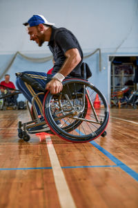 Side view of man riding bicycle on floor