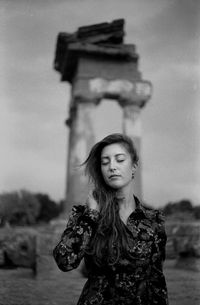 Young woman standing against ruins