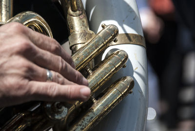 Cropped hand playing musical instrument outdoors