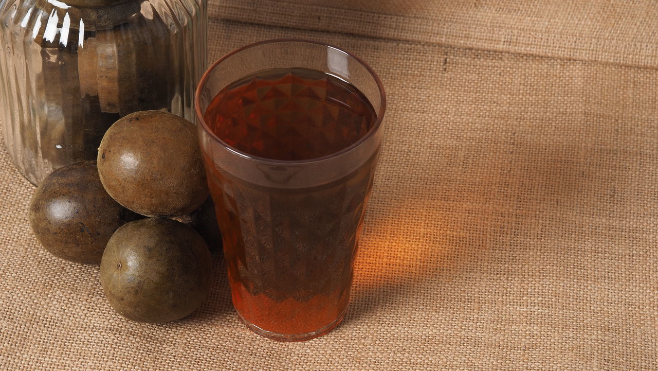 HIGH ANGLE VIEW OF FRUITS IN GLASS CONTAINER ON TABLE