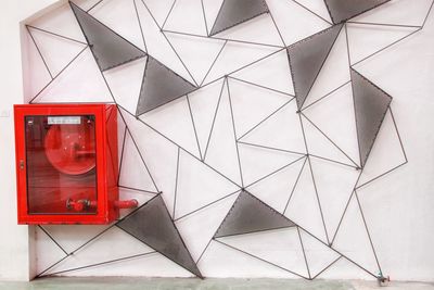 Low angle view of telephone booth against wall