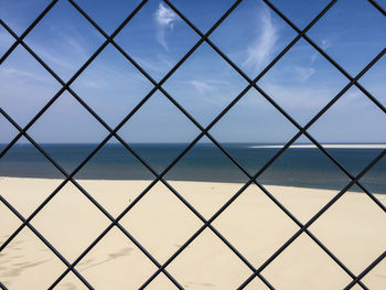 Full frame shot of chainlink fence against sky