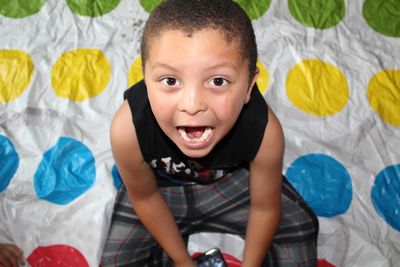 High angle portrait of with mouth open sitting on bed