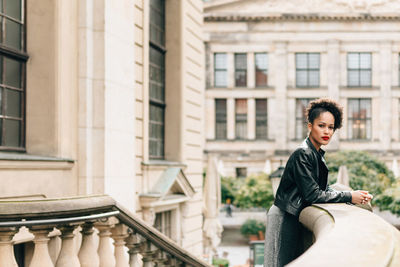 Portrait of woman sitting outside building
