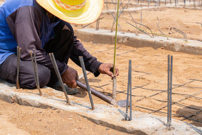 The worker hammered peg to measure the level of mortar in construction site.