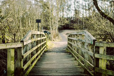 Wooden footbridge amidst trees