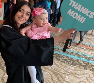 Portrait of mother with daughter standing against graffiti