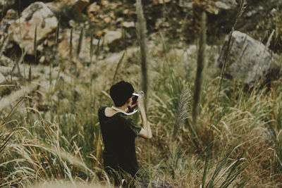 Woman photographing on field