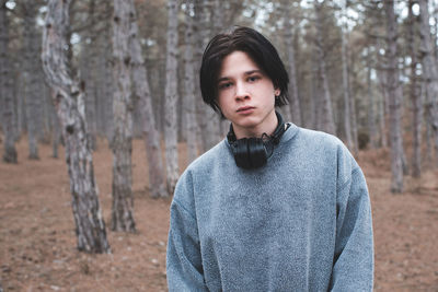 Portrait of young woman standing in forest