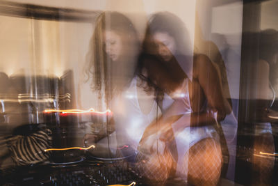 Blurred motion of young woman playing music at home