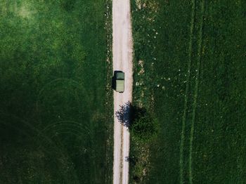 Aerial view of truck on dirt road amidst grassy field