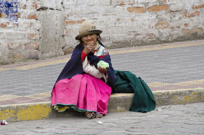 Full length of woman sitting on bench