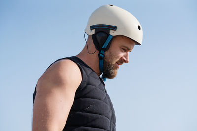 Low angle portrait man wearing helmet and life vest