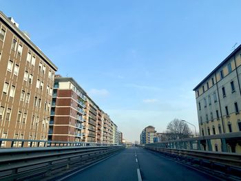 Road amidst buildings against sky in city