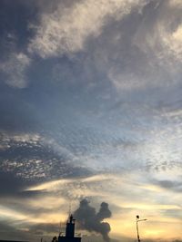 Low angle view of silhouette building against dramatic sky