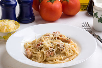 High angle view of spaghetti with carbonara in plate on table