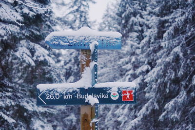 Close-up of road sign on snow covered mountains