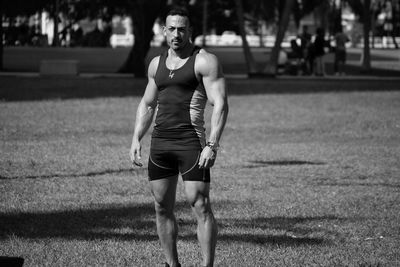 Portrait of muscular man standing on field