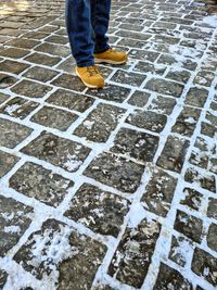 Low section of person standing on wet street