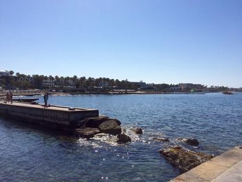 Scenic view of river against clear blue sky