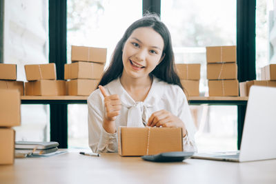 Portrait of a smiling young woman using phone