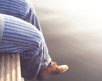 Low section of man on deck over lake