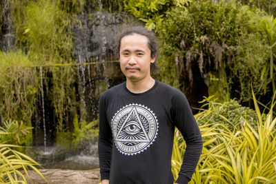 Portrait of young man standing in forest