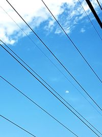 Low angle view of power lines against blue sky