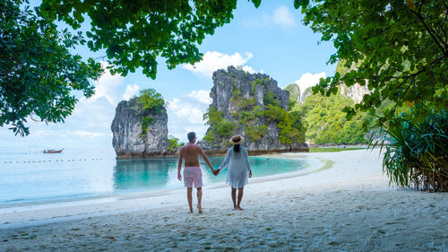 Rear view of woman walking at beach