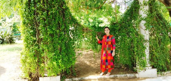 Portrait of woman standing against plants