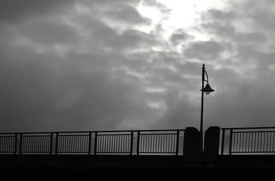 Low angle view of bridge against cloudy sky