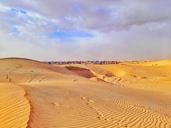 Sand dunes in desert against sky