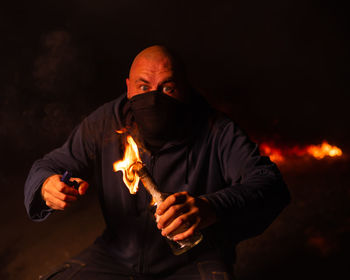 Portrait of man holding molotov cocktail