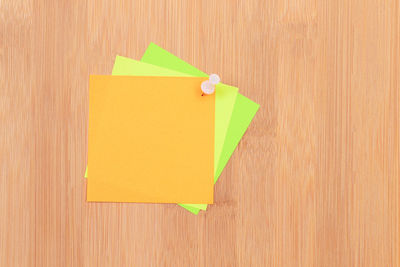 Directly above shot of yellow paper on wood