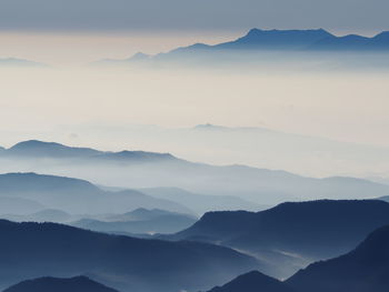 Scenic view of mountains against sky with fog