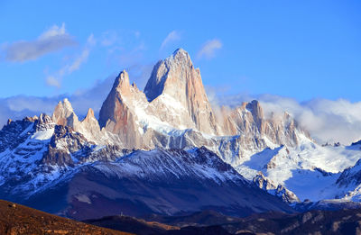 Panoramic view of snowcapped mountains against blue sky