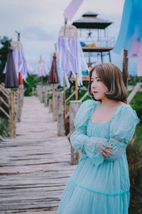 Thoughtful woman standing on boardwalk