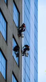 Low angle view of people working on building