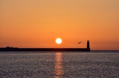 Scenic view of sea against orange sky