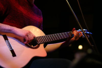 Midsection of man playing guitar