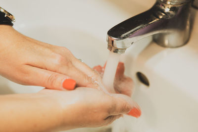 A woman washing her hands in the bathroom at home