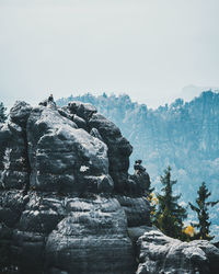 Statue on rock against sky