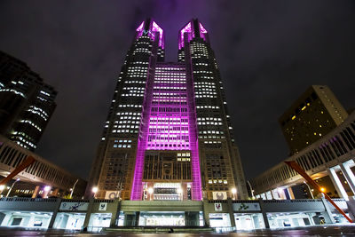 Low angle view of illuminated buildings against sky at night