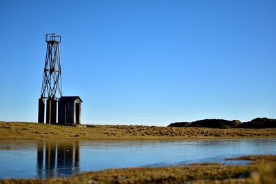 Built structure in water against clear blue sky